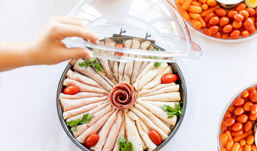 A person opens the clear lid of a sample dome to access food items