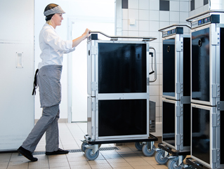 Female chef rolling a Scan Box unit in a kitchen