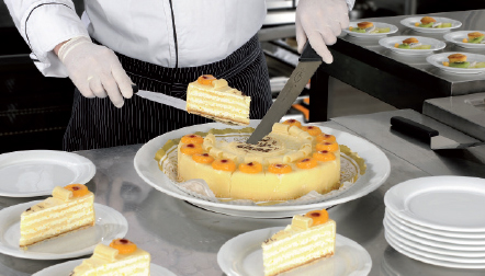 Professional chef cutting a cake in a kitchen